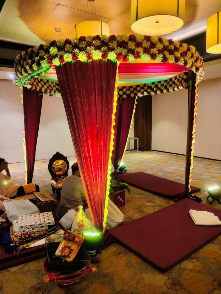 Floral mandap canopy setup with red velvet drapes for a wedding ceremony by Mayur Events Bilaspur