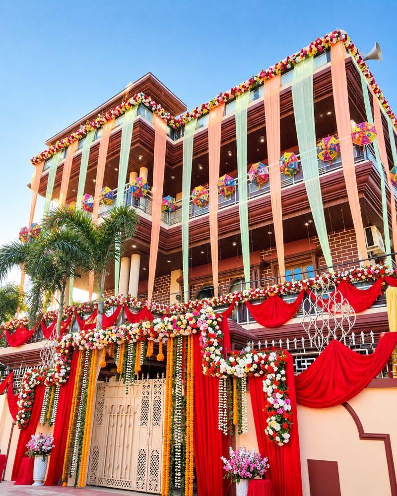 Wedding venue entrance facade decorated with drapes, garlands and Rajasthani umbrellas by Mayur Events Bilaspur